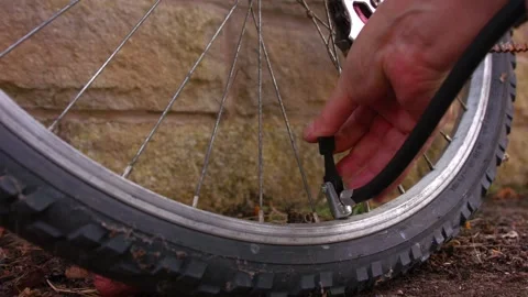 Cyclist pumping flat tyre on bicycle Stock Footage 344690035