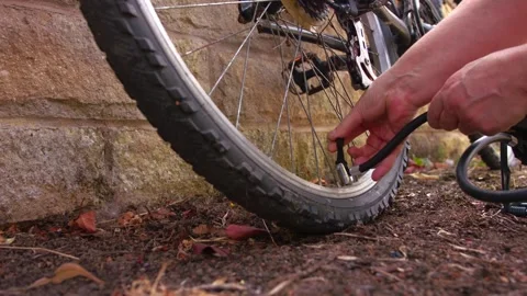 Cyclist pumping flat tyre on bicycle Stock Footage 344690080