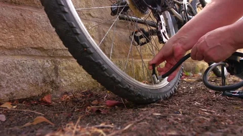 Cyclist pumping flat tyre on bicycle Video stock 344747664