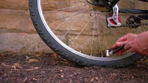 Cyclist pumping flat tyre on bicycle 库存影片 345159641