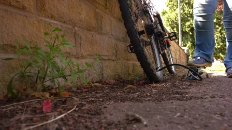 Cyclist pumping flat tyre on bicycle Stock Footage 346241598