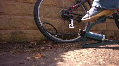 Cyclist pumping flat tyre on bicycle Stock Footage 346244230