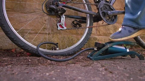 Cyclist pumping flat tyre on bicycle Stock Footage 346771868