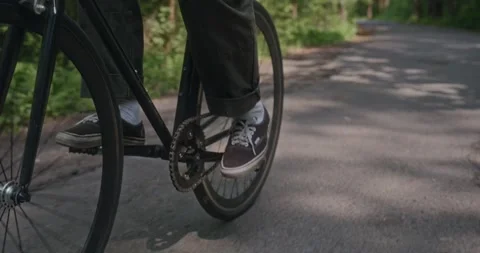 Cyclist pushes off and starts riding on forest road Stock Footage 311934853