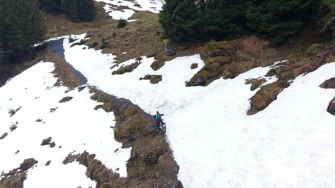 Cyclist pushing bike through deep snow on mountain road Видео 333070464