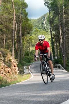 Cyclist raising mountain in highway Stock Photos