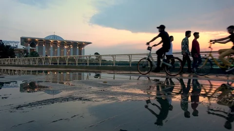 Cyclist reflected in puddle in front Sultan Mizan Zainal Abidin Mosque Putraj Video stock 106947738