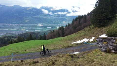 Cyclist resting on mountain road overlooking valley drone orbit Stock Footage 333070542