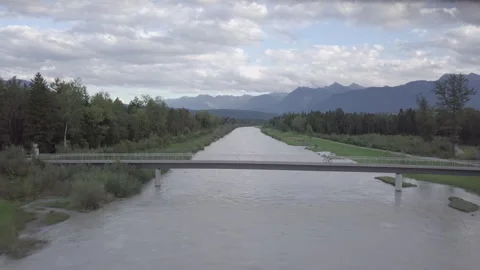 Cyclist Rides Across The Bridge Over Rough River (Rhein, Vorarlberg, Austria) Stock Footage 264045738