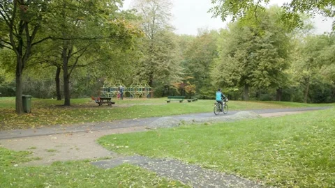 Cyclist rides along the Path in the Green Path  Stock Footage 132865334