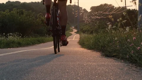 Cyclist rides away into the sunset Stock Footage