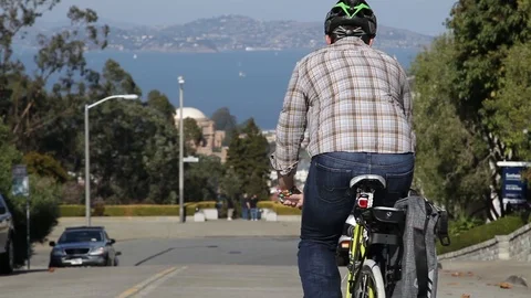 Cyclist rides down a hilly road in San Francisco Stock-Footage 90822380