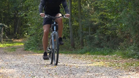 A cyclist rides down a path through a rural area - front view Stock-Footage 103244801