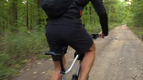 A cyclist rides down a pathway through a countryside - closeup Stock Footage 103247150