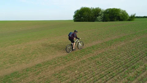Cyclist rides up the field. Stock Footage 129629389