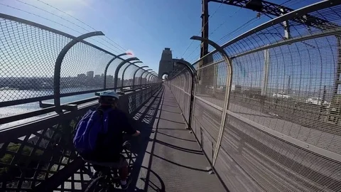Cyclist rides into frame on Sydney's Harbour Bridge. Stock Footage