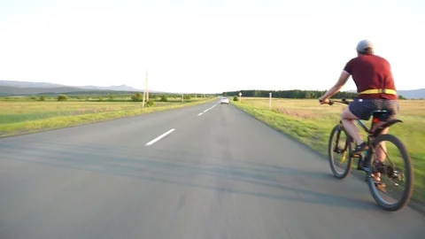 Cyclist rides on the highway Stock Footage 112989872
