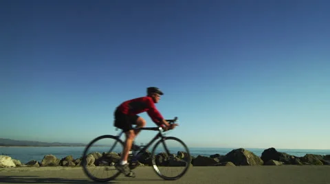 Cyclist Rides by the Ocean Stock Footage 62890557