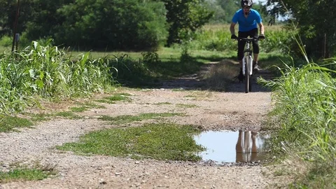 Cyclist rides on a puddle 動画素材 116479047