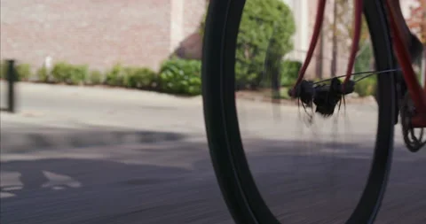 Cyclist rides a red bicycle through an urban neighborhood Stock Footage 186833994