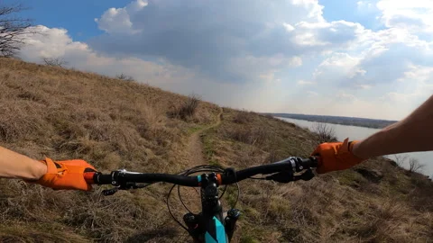 The cyclist rides a technical trail along the river. First person view. Stock Footage 151546587