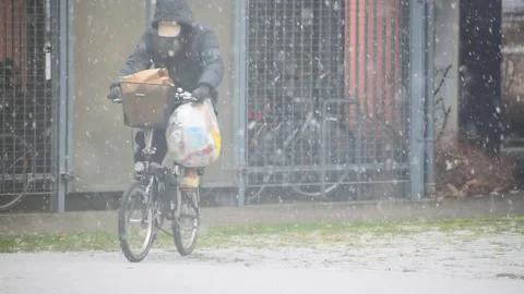 Cyclist Rides Through Falling Snow With Shopping Bags Stock Footage 343447486