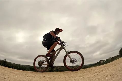 Cyclist rides through the sand on a cloudy day Foto stock