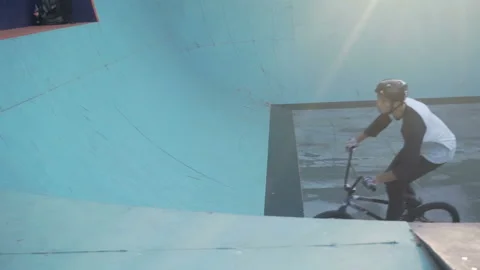 Cyclist rides on a wall in skate park and jumps Stock-Footage 103244053