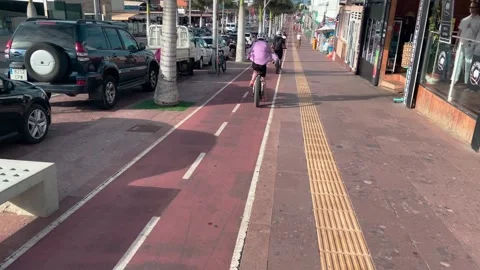 Cyclist riding along cycle path along Av. Ntra.Sra. del Carmen Stock Footage 221426968