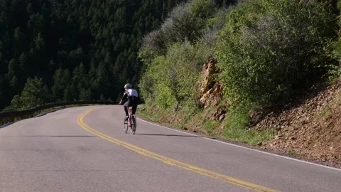 Cyclist Riding up Mountain Road Stock Footage 168760845