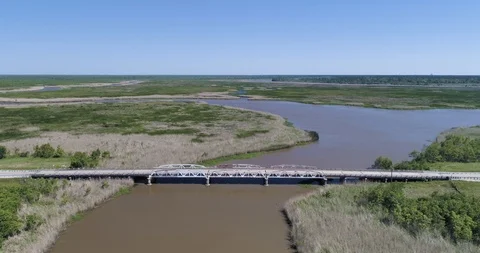 Cyclist riding over bridge through amazing marshland  drone aerial 4K Video stock 111364571