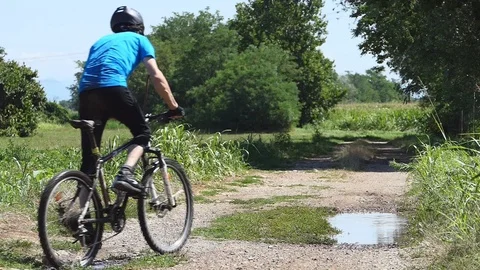 Cyclist riding on a puddle Stock Footage 116480222