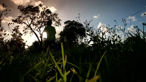 Cyclist Riding By Thick Grass in Foreground Stock Footage 200885340
