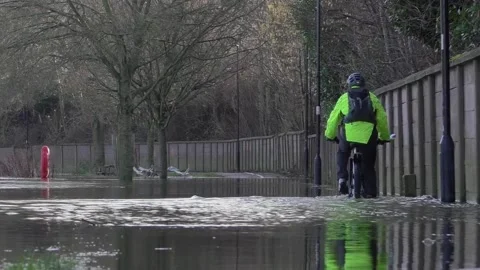 Cyclist Riding Through Flood Stock Footage 230936512