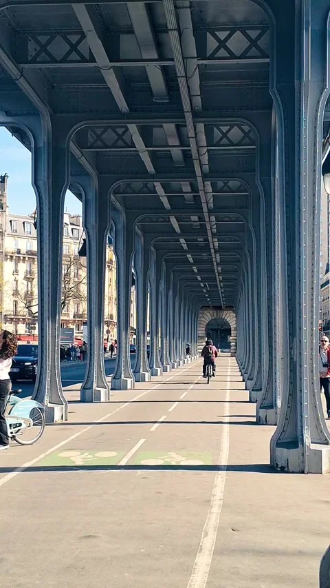 Cyclist Riding Under Pont de Passy Metal Columns  Paris, April 3, 2025 Stock Footage 311655120