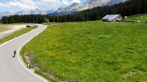 A cyclist on the road in an alpine valley Stock Footage 112332575