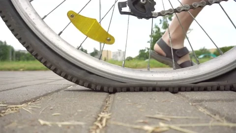 A cyclist rolls a bicycle with a flat, punctured wheel, close-up. Punched wheel Stock Footage 140782377