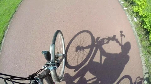 Cyclist shadow and front wheel 4k Stock Footage 52939080