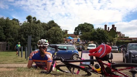 Cyclist sitting on the grass taking a break Stock Footage 77074666