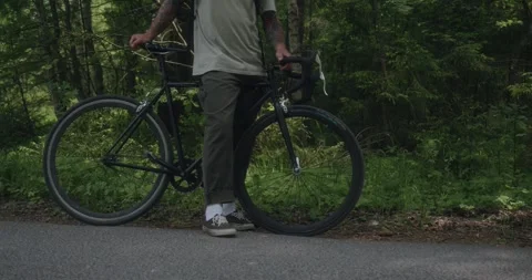 Cyclist standing alone on the forest roadside Video stock 311920141