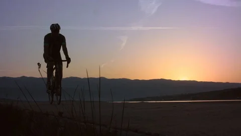 Cyclist Starting His Tour Before Sun Has Risen, Riding Towards The Camera Stock Footage