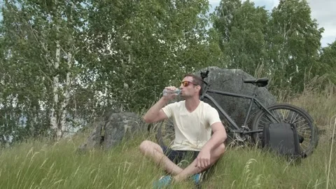 The cyclist stopped to rest and drinks water Stock Footage 246937248