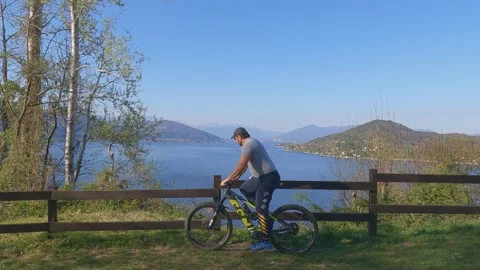 Cyclist stops to enjoy panoramic view over Lake Maggiore, Italy Stockbeeldmateriaal 280881910