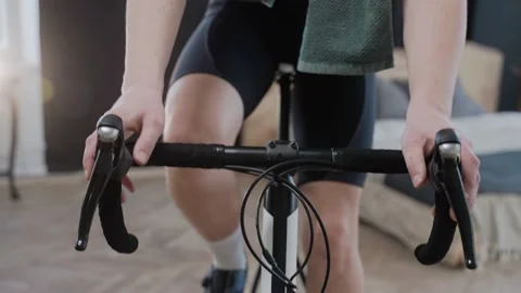 A cyclist stops training on an exercise bike at home and breathes heavily Stock-Footage 171117566