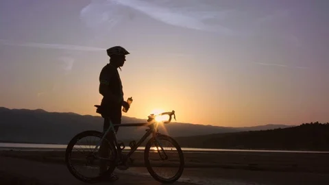 Cyclist Taking A Drink At Beach Pier In Time Of A Beautiful Sunrise Stock Footage 93660423