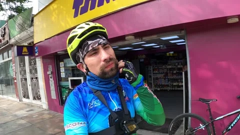 A cyclist talking to the camera outside a store on the street Stock Footage 145100241