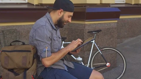 Cyclist uses tablet on the street Stock Footage 76617079