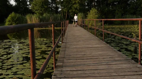 Cyclist walking over the bridge Stock Footage 31212595