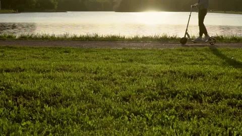 Cyclists and skaters rolling through the alley of the city Park in early spri Stock Footage 132723638