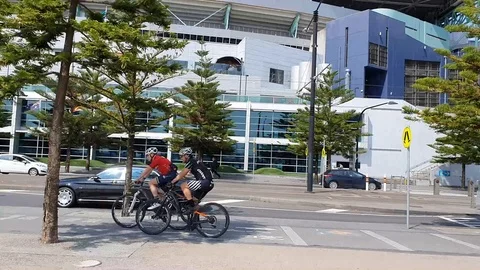 Cyclists and Tram at Docklands Stock Footage 123399656